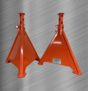 Two orange steel heavy duty adjustable jackstands or equipment stands resting on a metal surface,